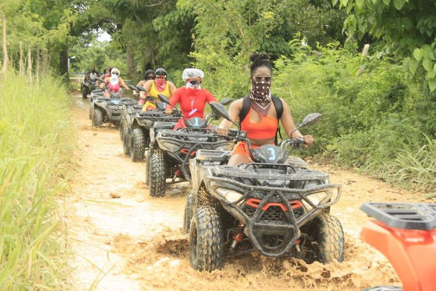 Caravana de ATV por un camino de tierra entre la vegetación