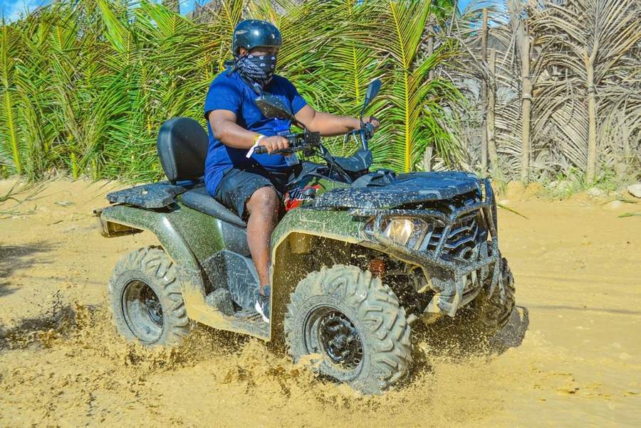 ATV cruzando la arena entre palmeras