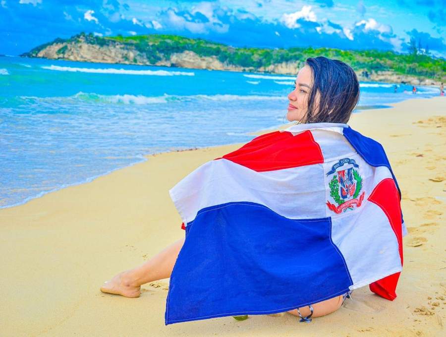 Turista con la bandera dominicana en la playa Macao