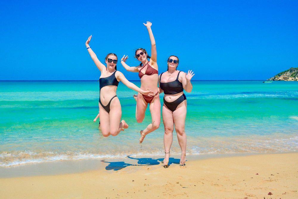 Tres amigas saltando en la arena de playa Macao frente al mar