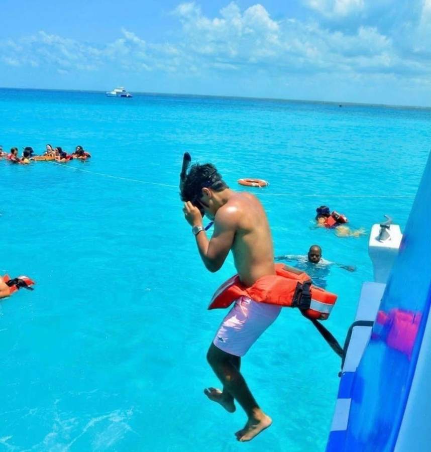 Turista saltando al mar turquesa desde el barco para hacer snorkel