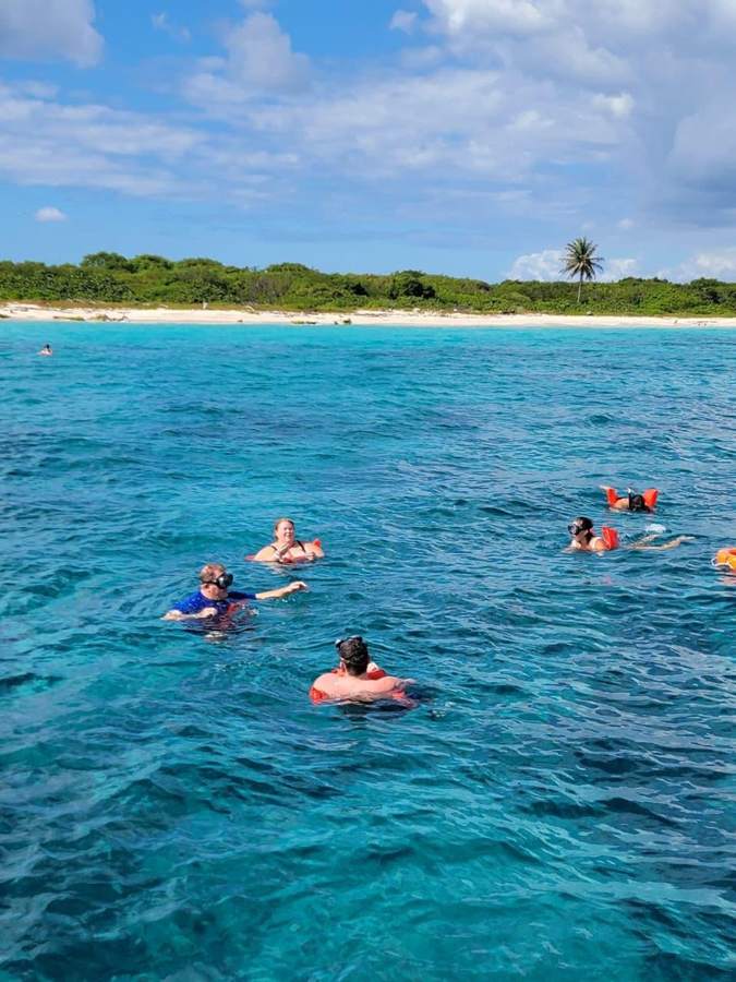Grupo haciendo snorkel con chalecos frente a la playa de Isla Catalina