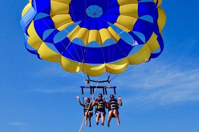 Tres personas volando juntas en parasailing sobre Punta Cana
