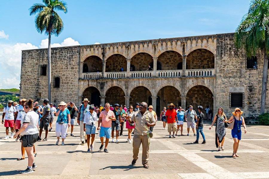 Grupo de visitantes con su guía frente al Alcázar de Colón en la Zona Colonial