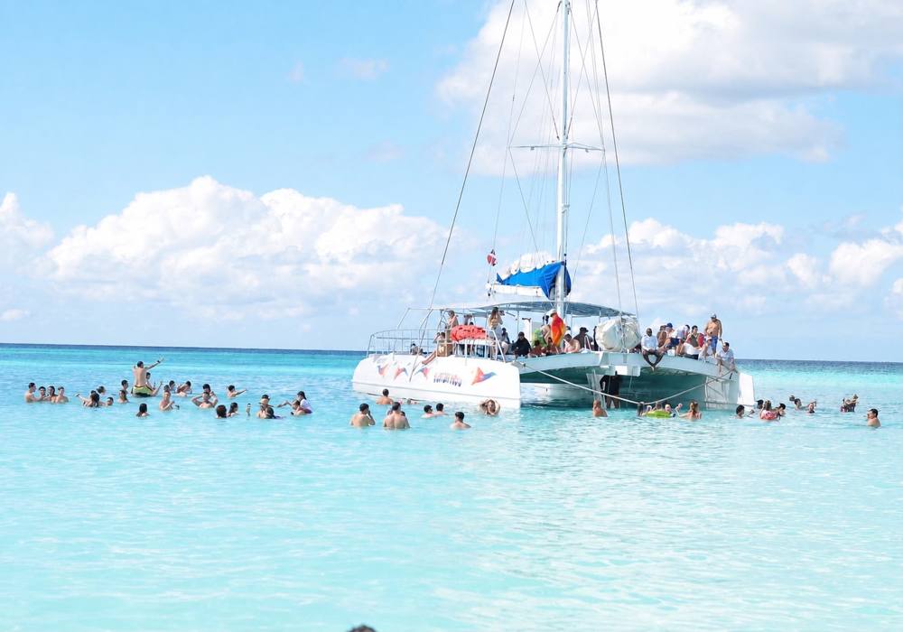 Catamarán anclado en aguas turquesa con bañistas