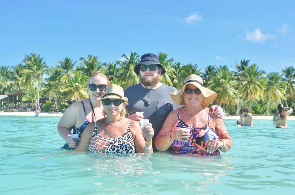 Familia en la piscina natural con palmeras al fondo