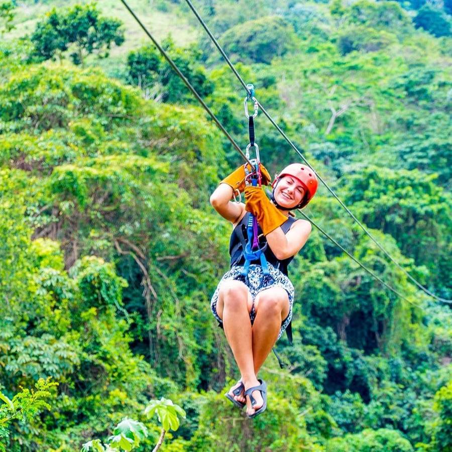 Mujer sonriendo en el zipline sobre la selva de Punta Cana