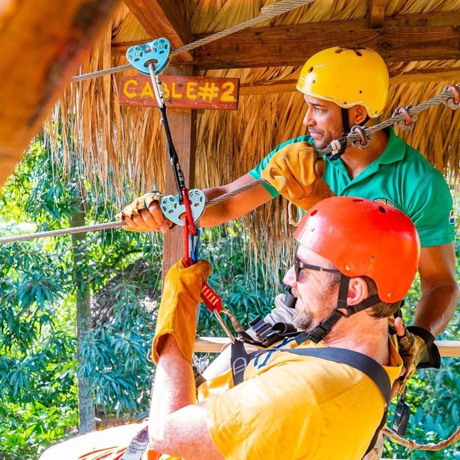 Guía certificado enganchando a un turista en el cable del zipline